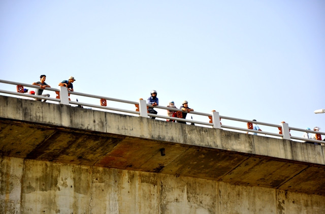 Khu vực trên cầu Thanh Trì, nhiều người qua đường vẫn dừng lại nhìn xuống khu vực mọi người tập trung có thể tìm thấy xác chị Huyền chưa.