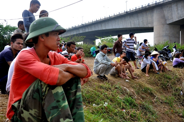 Những nét mặt lặng lẽ hướng về dòng sông để hi vọng xác chị Huyền nổi lên.
