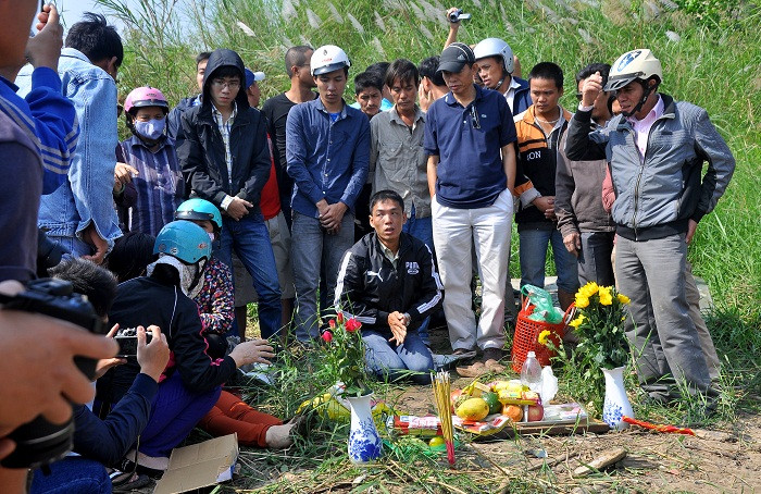 Gia đình và anh Huy quỳ lậy trước bàn làm lễ trên bờ đê sông Hồng. Gia đình và anh Huy quỳ lậy trước bàn làm lễ trên bờ đê sông Hồng.