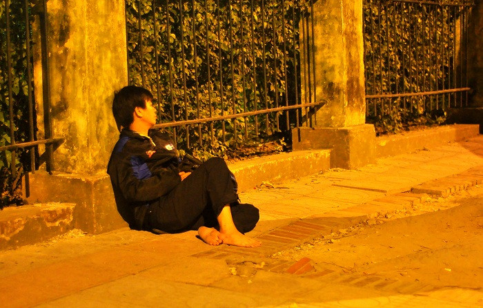 Người ngồi cạnh bờ tường để tranh thủ chợp mắt