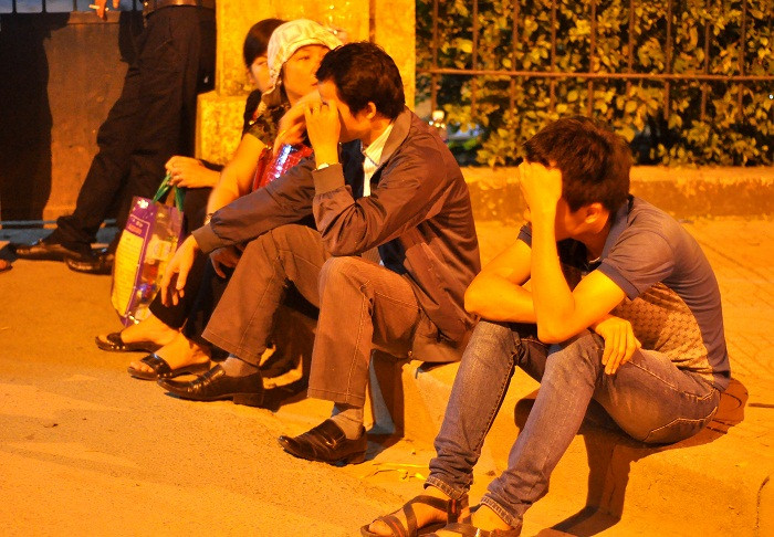 Nhiều người ngồi ngay trước cổng tranh thủ chợp mắt.