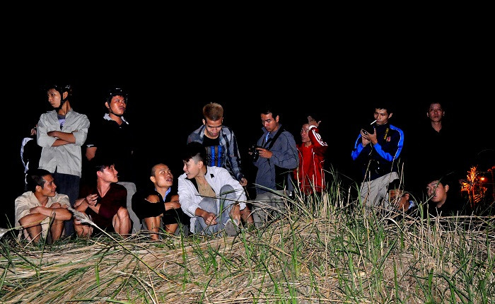 Dù trời đã khuya nhưng mọi người vẫn ngồi trước dòng sông Hồng (nơi được khoanh vùng để tìm kiếm xác nạn nhân).