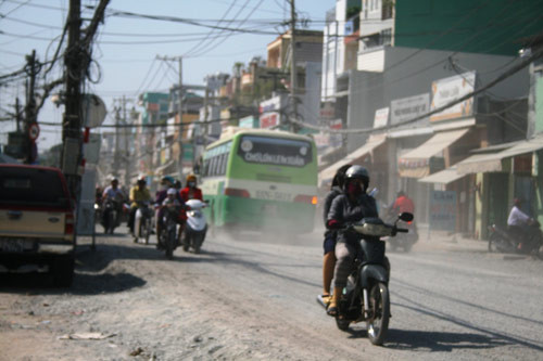Mặt đường lổm chổm đá dăm và bụi bay mù mịt