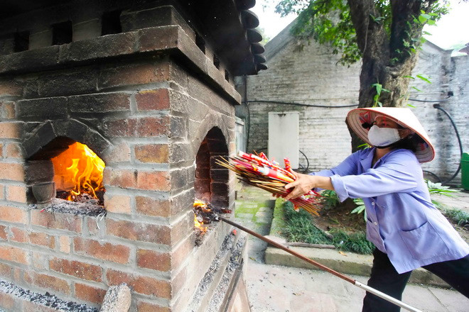 Nhân viên của Ban quản lý di tích Văn Miếu - Quốc Tử Giám gom nhang và xử lý