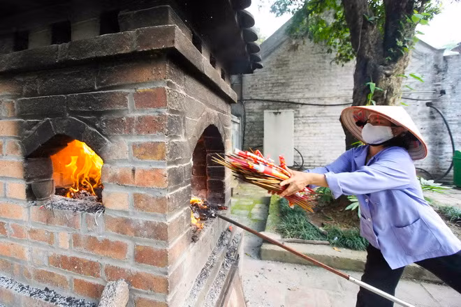Nhân viên của Ban quản lý di tích Văn Miếu - Quốc Tử Giám gom nhang và xử lý