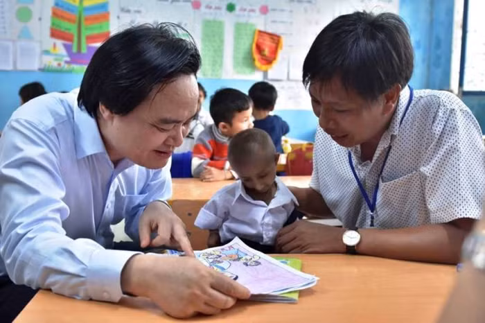 Bộ trưởng Phùng Xuân Nhạ xúc động gặp lại cậu bé tý hon Đinh Văn K'Rễ. Ảnh: CTV