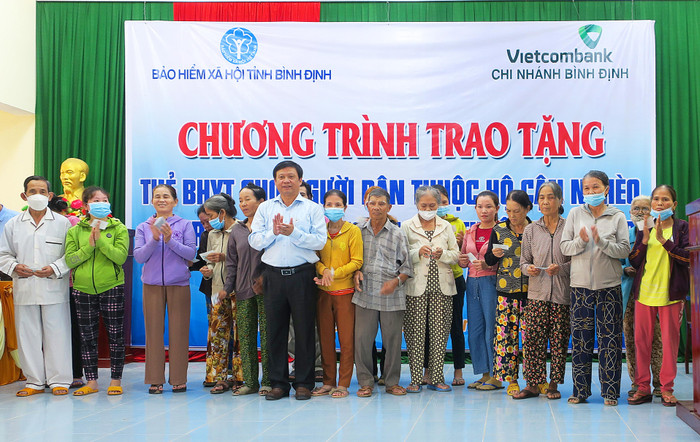 Giám đốc Bảo hiểm xã hội tỉnh Võ Năm tặng thẻ bảo hiểm y tế cho người dân thuộc hộ cận nghèo huyện An Lão.