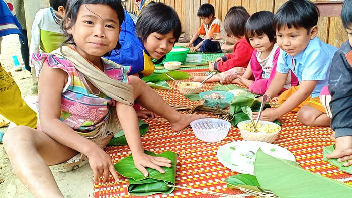 Một học sinh người Ca Dong rất vui vì được gói bánh. Một học sinh người Ca Dong rất vui vì được gói bánh.