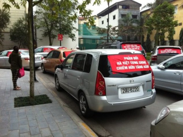 Cư dân đỗ xe và giăng băng rôn để phản đối mức phí của chủ đầu tư