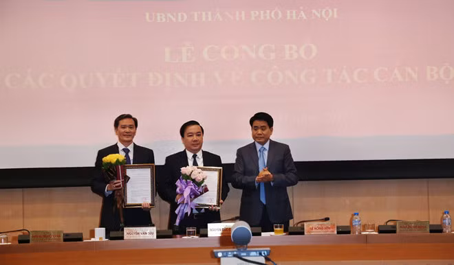 Chủ tịch Ủy ban nhân dân thành phố Hà Nội Nguyễn Đức Chung trao quyết định bổ nhiệm chức vụ Giám đốc Sở Giáo dục và Đào tạo Hà Nội cho ông Chử Xuân Dũng (đứng giữa). Ảnh: Sở Giáo dục và Đào tạo Hà Nội.