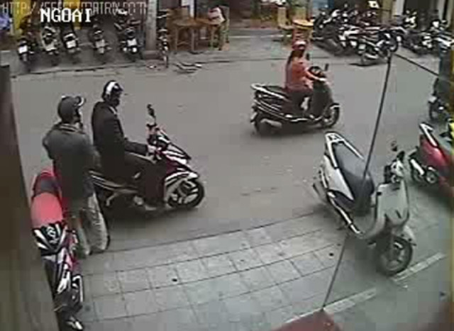 Tên ngồi sau lại lấy mũ bảo hiểm đội lên. Trong khi đó, tên còn lại vẫn liên tục áp điện thoại vào tai để đánh lạc hướng người đi đường. Tên ngồi sau lại lấy mũ bảo hiểm đội lên. Trong khi đó, tên còn lại vẫn liên tục áp điện thoại vào tai để đánh lạc hướng người đi đường.