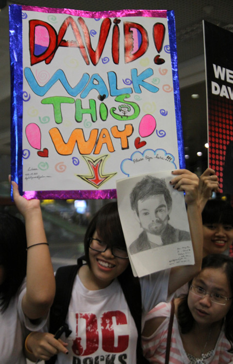 Các fan Việt với băng rôn, khẩu hiệu đã sẵn sàng chào đón thần tượng âm nhạc Mỹ David Cook đến Việt Nam tại sân bay Nội Bài trong một đêm mưa gió giữ tháng 6 năm 2011. (Ảnh: VNN)