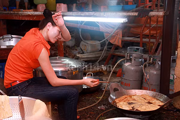 Trang Trần vừa chiên mì căn, vừa vất vả lau mồ hôi. (Theo Kênh 14)