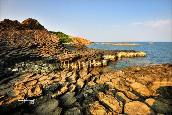 Những tảng đá xếp chồng nhau đón ánh nắng chiều vàng rượm, màu sắc của đá biến đổi theo màu nắng, sáng rực giữa làn nước trong xanh. Những tảng đá xếp chồng nhau đón ánh nắng chiều vàng rượm, màu sắc của đá biến đổi theo màu nắng, sáng rực giữa làn nước trong xanh.