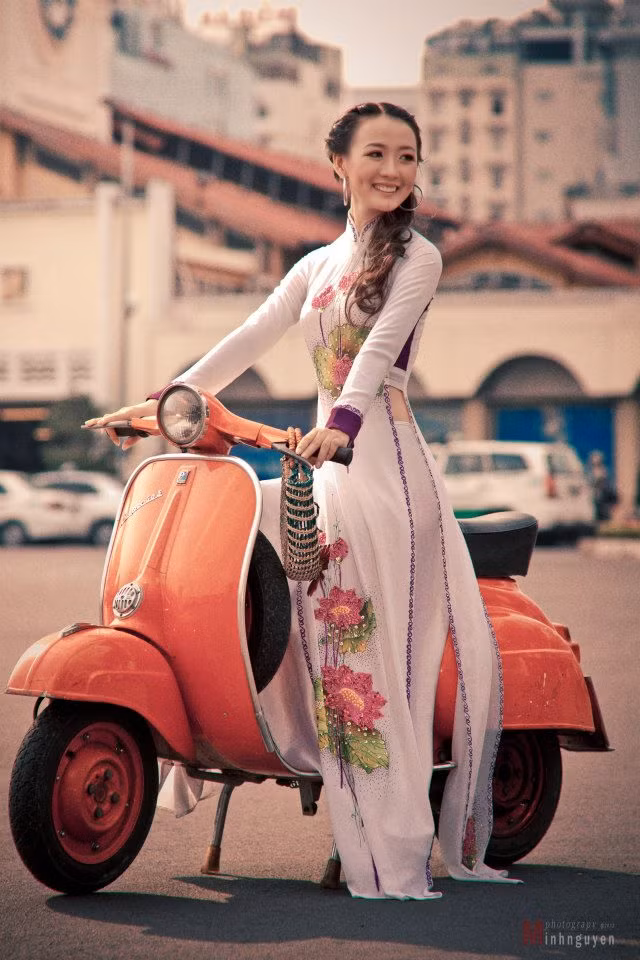 Trong tà áo dào truyền thống, Thu Thảo yêu kiều, duyên dáng bên chiếc xe Vespa màu cam ấn tượng và nổi bật