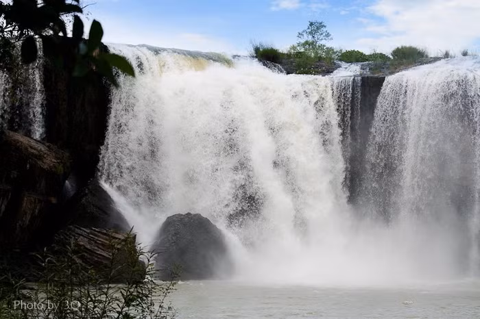 Thác nước từ trên cao đổ xuống ào ạt, trắng xóa.