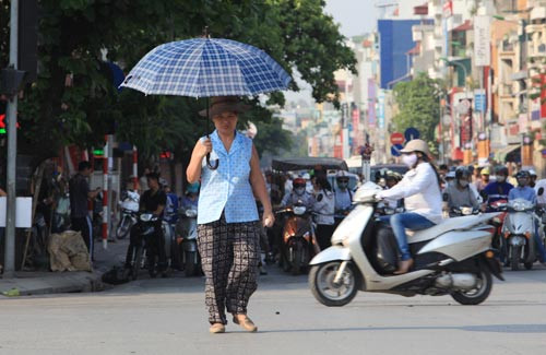 Người che ô, người mặc áo chống nắng, người nép vào bóng râm để tránh cái nắng đầu hè Người che ô, người mặc áo chống nắng, người nép vào bóng râm để tránh cái nắng đầu hè