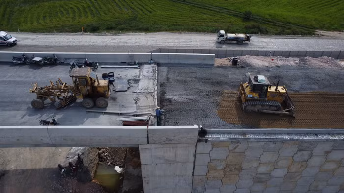 Các công nhân đang thực hiện việc đầm nền tại vị trí máy ủi và xe lu không tiếp cận được. Ảnh: T.D