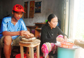 Hào Anh giúp mẹ lột tỏi thuê tại nhà riêng của mình ở phường 8, TP Cà Mau. Ảnh: TRẦN VŨ