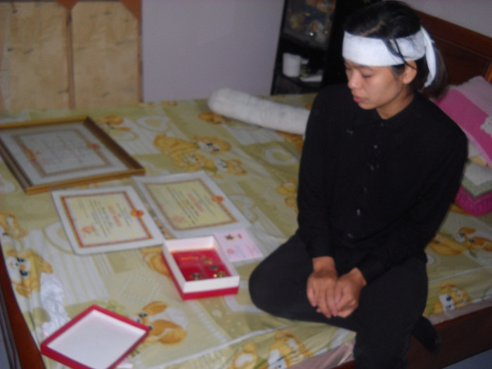 Chị Xoa bên những bằng khen và huân huy chương của chồng