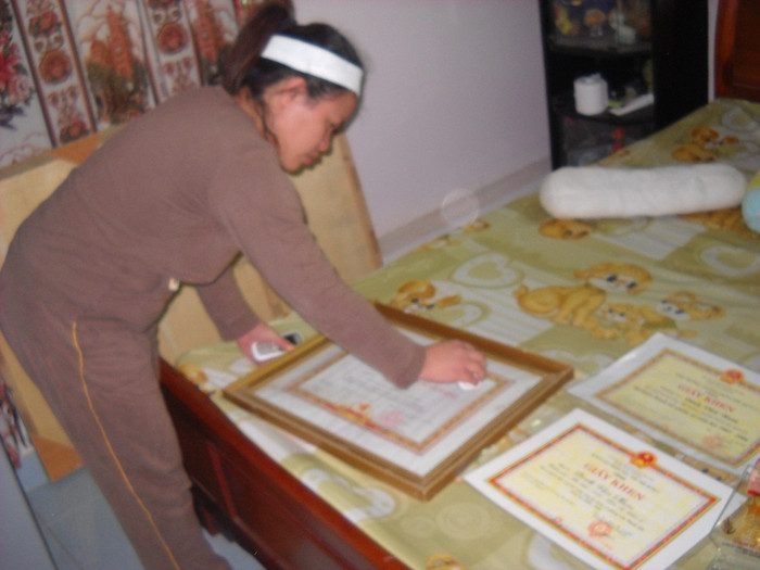 Em gái trung úy Nam đang lau chùi những bằng khen của anh