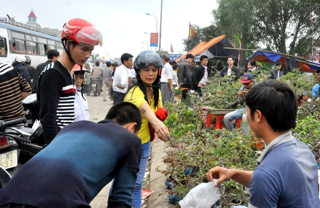 Phía bên ngoài đền, chợ Viềng vẫn sôi động cảnh mua người bán.