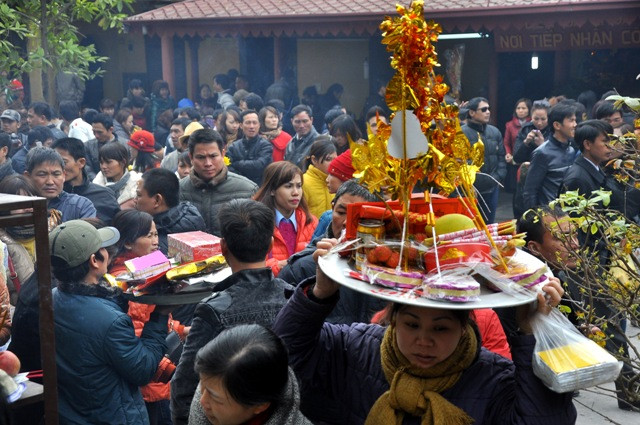 Trong dòng người đông đúc, những mâm lễ được đưa cao trên đầu để đi vào đền Bà Chúa Kho vay nợ. Trong dòng người đông đúc, những mâm lễ được đưa cao trên đầu để đi vào đền Bà Chúa Kho vay nợ.