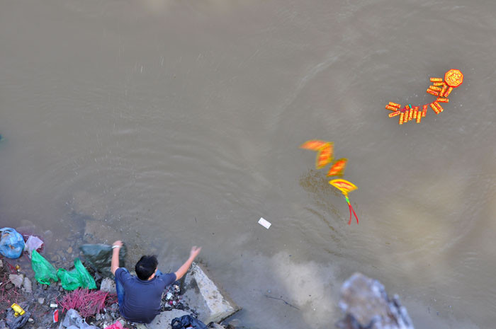 Một người dân tại chân cầu Long Biên còn thả cả một tràng pháo xuống sông Một người dân tại chân cầu Long Biên còn thả cả một tràng pháo xuống sông