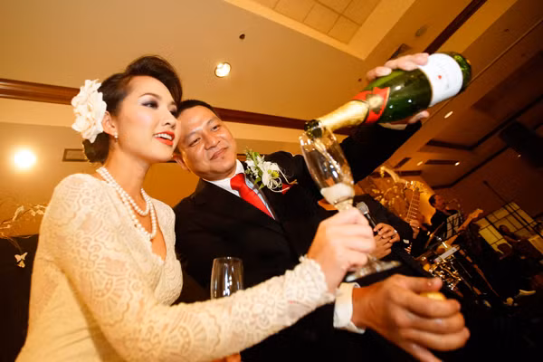 Cặp đôi cùng rót rượu mừng trong tiếng reo hò của mọi người.