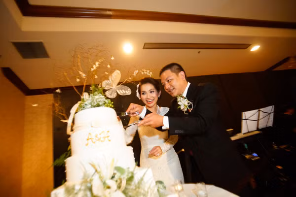 Đến giờ làm lễ, tân lang, tân nương tay trong tay tiến vào phòng tiệc. Trước khi thực hiện các nghi lễ cắt bánh, Kim Hiền đã thay bộ váy cưới ren trắng khác. Đây là trang phục mà cô đặt may riêng của nhà thiết kế Minh Tú.