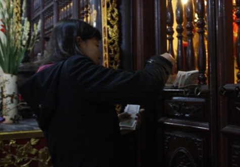 Không đưa được tiền lẻ vào trong, người phụ nữ này gài ngay tiền ở cánh cửa.