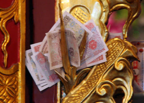 Tiền lẻ cài cả vào cánh cửa điện thờ. Tiền lẻ cài cả vào cánh cửa điện thờ.