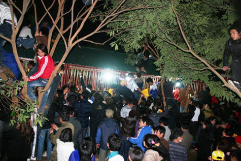 Không ít người đã trèo lên các cây xung quanh nơi phát ấn để tránh cảnh đông đúc và để có thể dễ mua được ấn hơn.