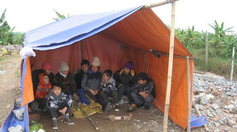 Vợ con ông Vươn, Quý phải dựng tạm lều trên khu đất căn nhà hai tầng đã bị phá để ở tạm từ ngày mùng 1 Tết. Vợ con ông Vươn, Quý phải dựng tạm lều trên khu đất căn nhà hai tầng đã bị phá để ở tạm từ ngày mùng 1 Tết.