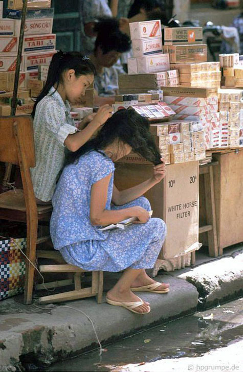 Cô con gái nhỏ đang tìm, nhổ những sợi tóc sâu cho mẹ. Cô con gái nhỏ đang tìm, nhổ những sợi tóc sâu cho mẹ.