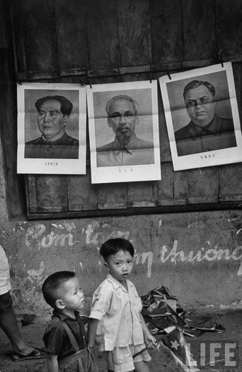 Hai anh em cùng dắt tay nhau đi đón mừng đoàn quân giải phóng thủ đô.