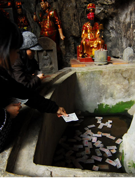 Tiền lẻ được rải cả xuống bể nước nhỏ trong chùa.