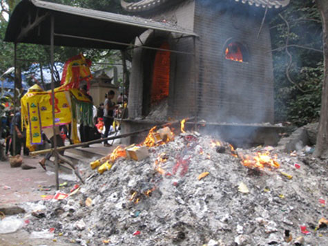 Vàng mã đốt tràn cả ra sân đền Chợ Củi (Nghi Xuân, Hà Tĩnh) thành đống lớn.