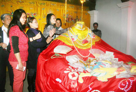 Đua nhau sờ cổ, đặt tiền lẻ lên tượng công chúa Mỵ Châu tại đền thờ An Dương Vương (Hà Nội).