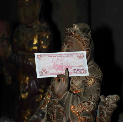 Tiền lẻ che cả mặt tượng. Tiền lẻ che cả mặt tượng.