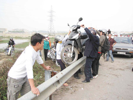 Ùn tắc quá lâu đã khiến nhiều người chọn cách khiêng xe qua dải phân cách để đi đường khác.