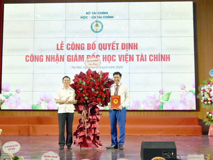 Ông Hồ Đức Phớc - Bộ trưởng Bộ Tài chính đã trao Quyết định và tặng hoa Nhà giáo ưu tú, Phó Giáo sư, Tiến sĩ Nguyễn Đào Tùng. Ảnh: hvtc.edu.vn. BN.4.jpg