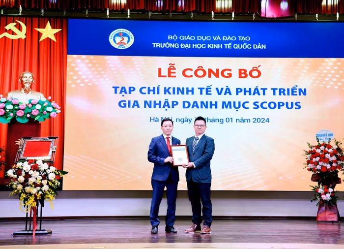 Ông Stan Lee, Giám đốc Nhà xuất bản Emerald khu vực châu Á - Thái Bình Dương trao chứng nhận Tạp chí Kinh tế và Phát triển (JED) gia nhập danh mục Scopus cho Giáo sư, Tiến sĩ Lê Quốc Hội, Tổng biên tập Tạp chí. Ảnh: NTCC.