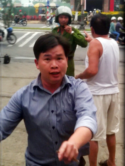 Ông Lịch (áo trắng) thóa mạ thượng úy Long còn ông Sơn quay lại giật điện thoại của hạ sĩ Tiến