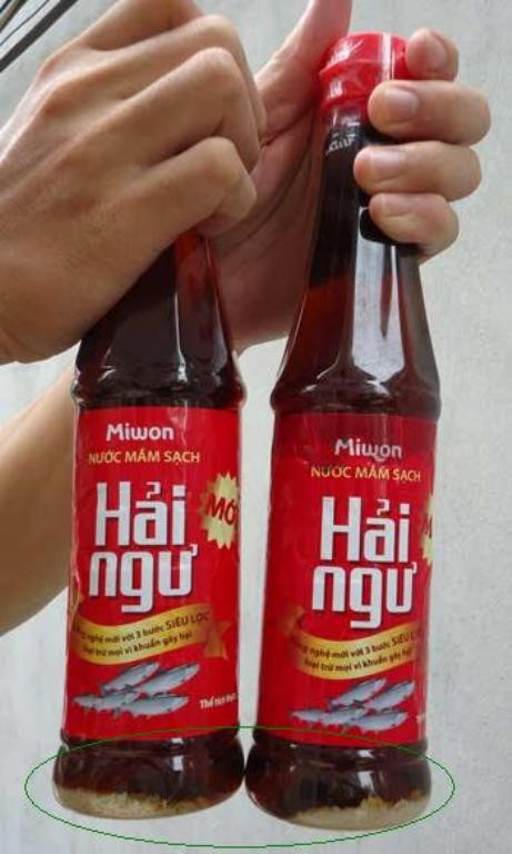 Hai chai nước mắm Miwon Hải Ngư bị đóng cặn kết tủa trắng (Ảnh do anh Tú cung cấp).
