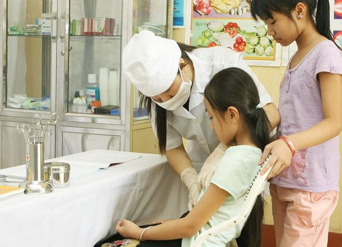 Từ năm học 2023 - 2024, vị trí việc làm y tế chuyển sang nhóm vị trí việc làm hỗ trợ, phục vụ. (Ảnh: Dương Ngọc/TTXVN) giao_vien_y_te.jpg