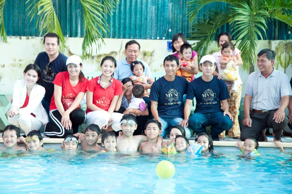 Đoàn từ thiện chụp ảnh chung với các em nhỏ. Ngồi bên phải Ngọc Trinh là ông Phan Minh Chánh, trưởng ban tổ chức cuộc thi Hoa hậu người Việt hoàn cầu 2011.