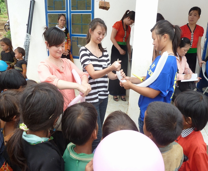 Tò mò, chăm chú, xúm quanh đoàn từ thiện để nhận đồ chơi và bóng bay.