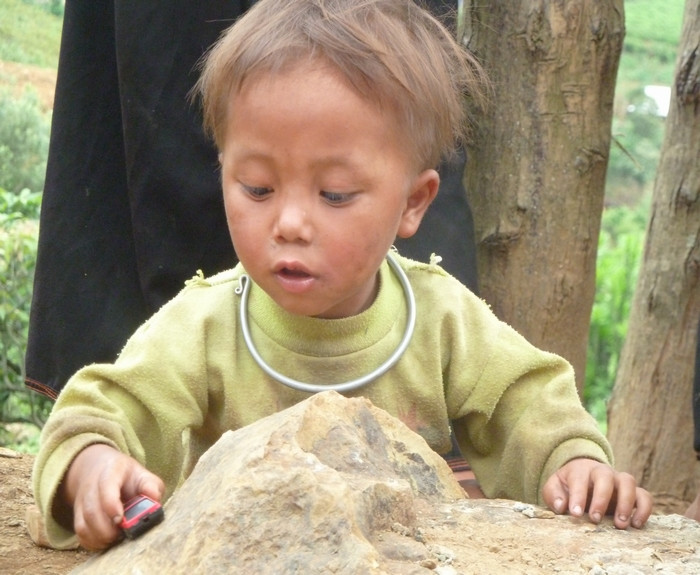 Chơi một mình một cách hăng say với quả bóng và chiếc ô tô đồ chơi nhỏ.