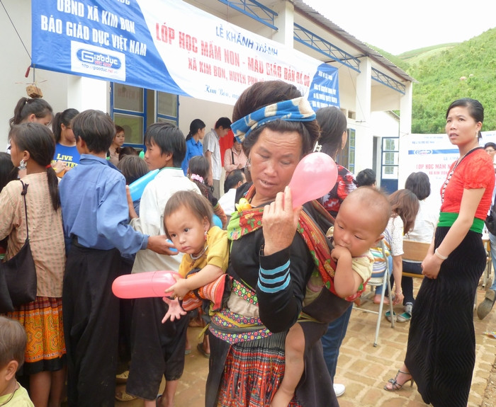 Vừa địu cháu, vừa đến nhận quà.